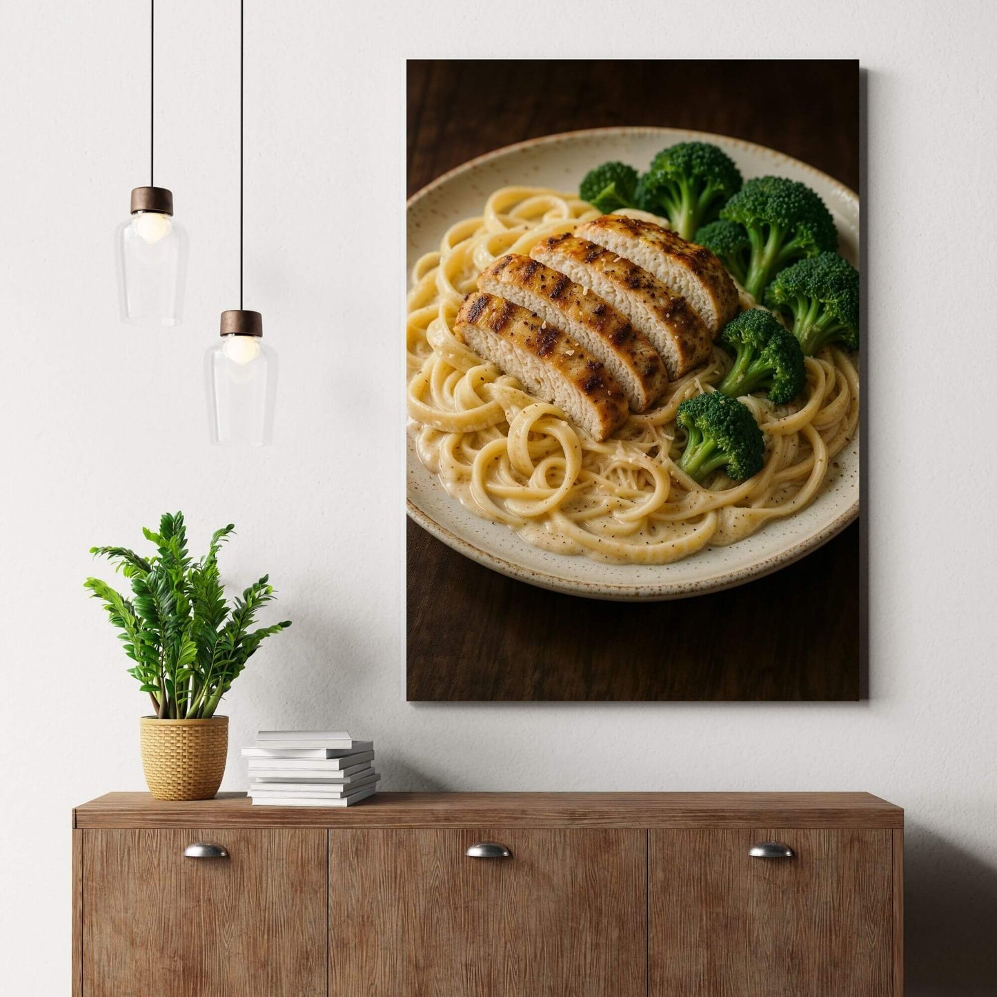Canvas print of chicken alfredo pasta with broccoli, placed on a wooden dresser next to a
potted plant and books, suitable for kitchen or dining room decor.
