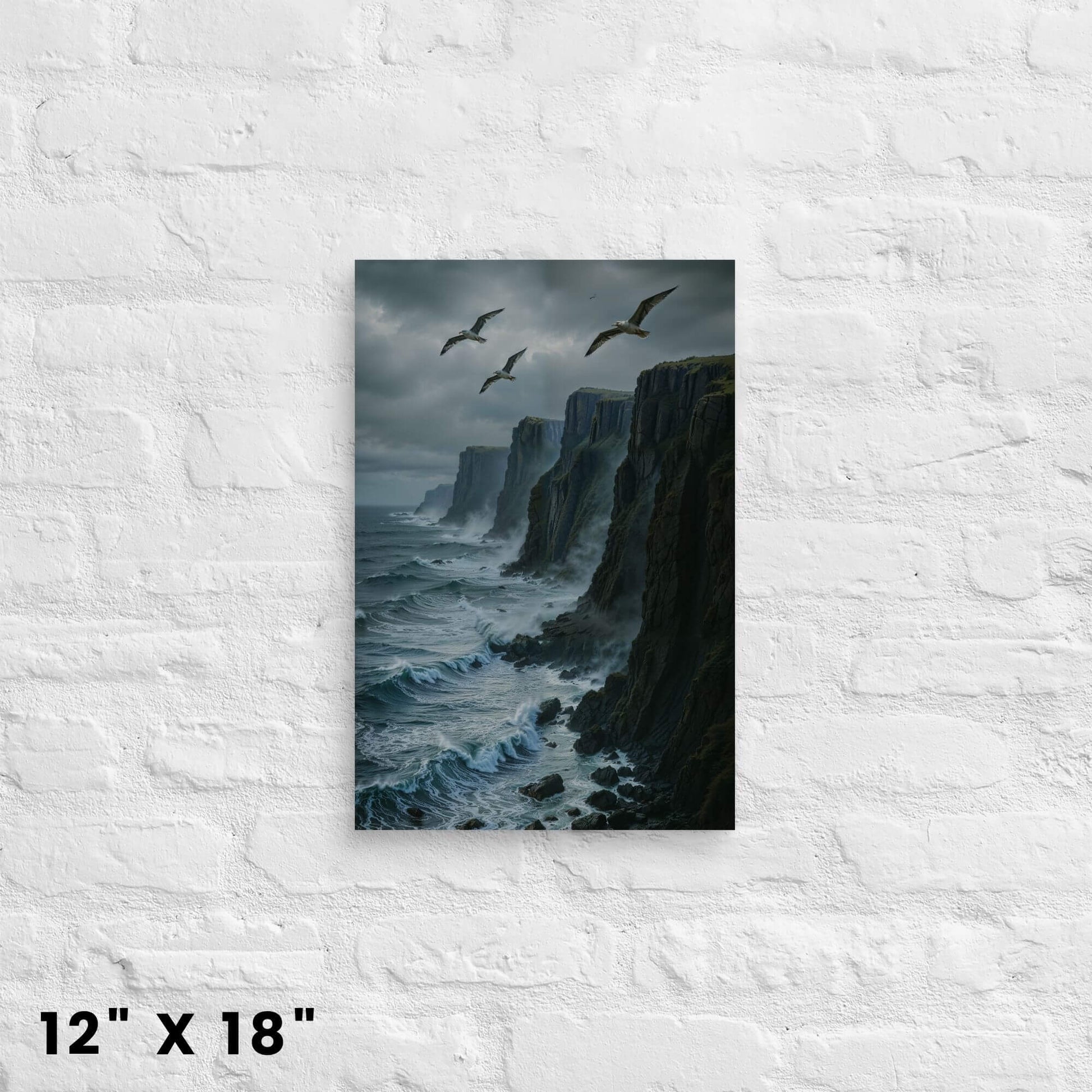 12"x18" canvas print of a dramatic coastal landscape with cliffs and seagulls over a turbulent sea, mounted on a white brick wall.
