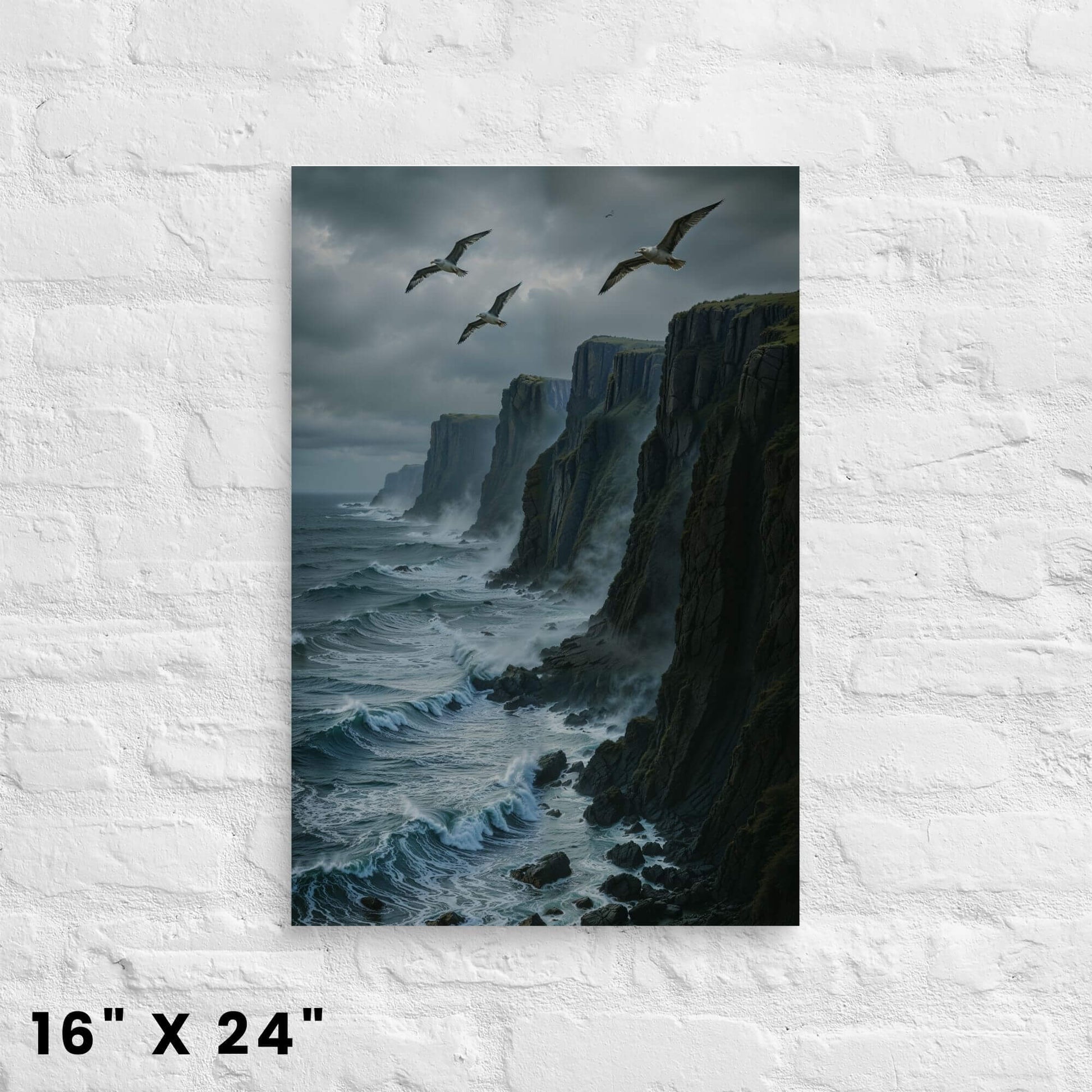 16"x24" canvas print featuring a striking coastal scene with tall cliffs, ocean waves, and seagulls in a stormy sky, displayed on a white brick wall.