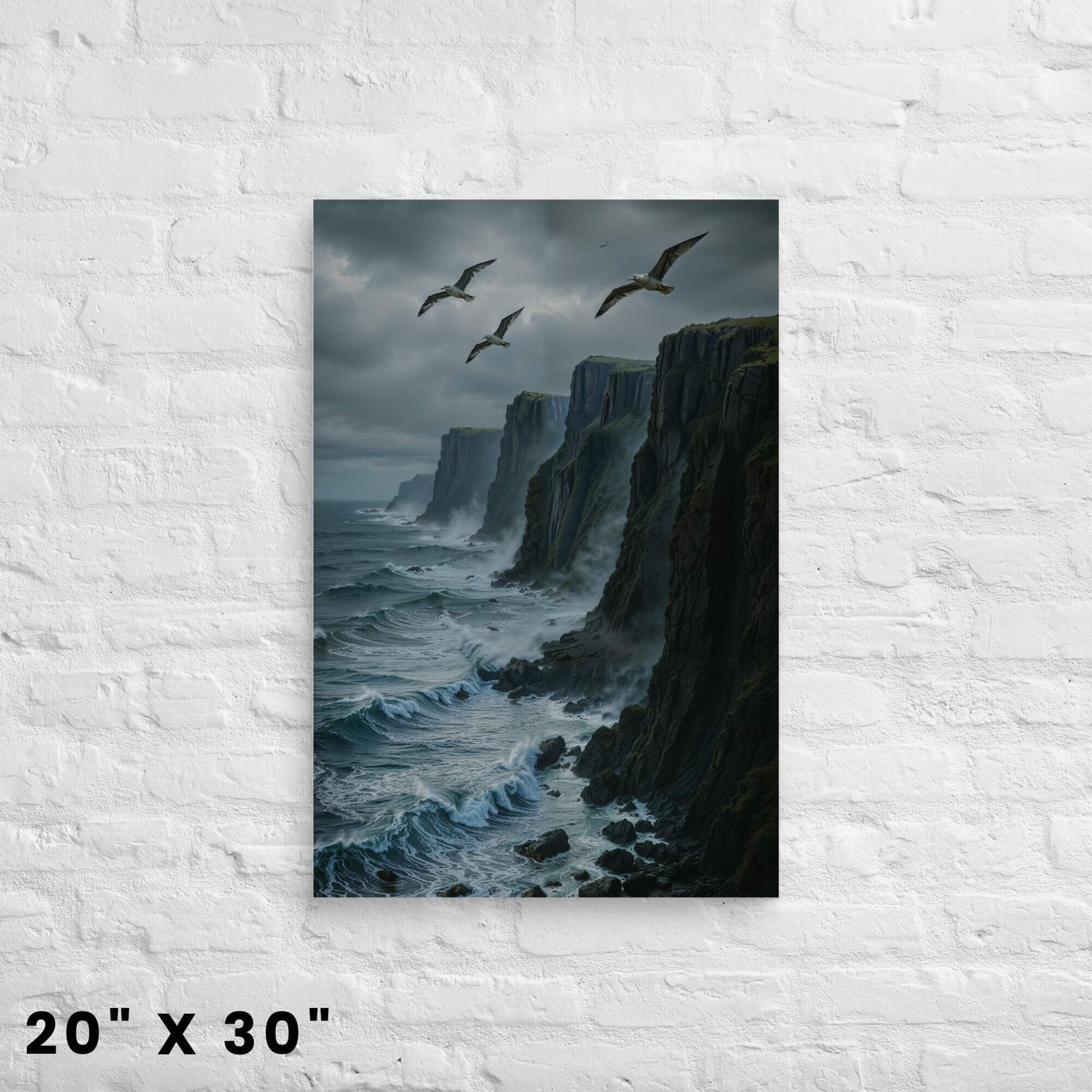 20"x30" canvas print of a dramatic sea cliff landscape with seagulls and powerful waves, hanging on a white brick wall.