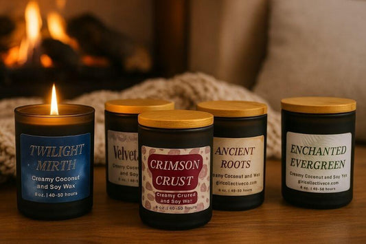 A collection of five lit Grit Collective creamy coconut and soy wax candles in black glass jars with bamboo lids, including Twilight Mirth, Velvet Lace, Crimson Crust, Ancient Roots, and Enchanted Evergreen, set against a cozy background with a fireplace.