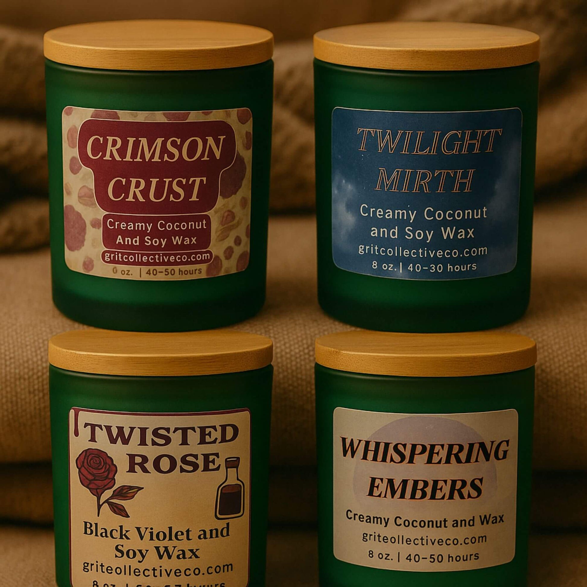 A group of four Grit Collective creamy coconut and soy wax candles in green glass jars with bamboo lids, showing the Crimson Crust, Twilight Mirth, Twisted Rose (Black Violet and Soy Wax), and Whispering Embers scents.