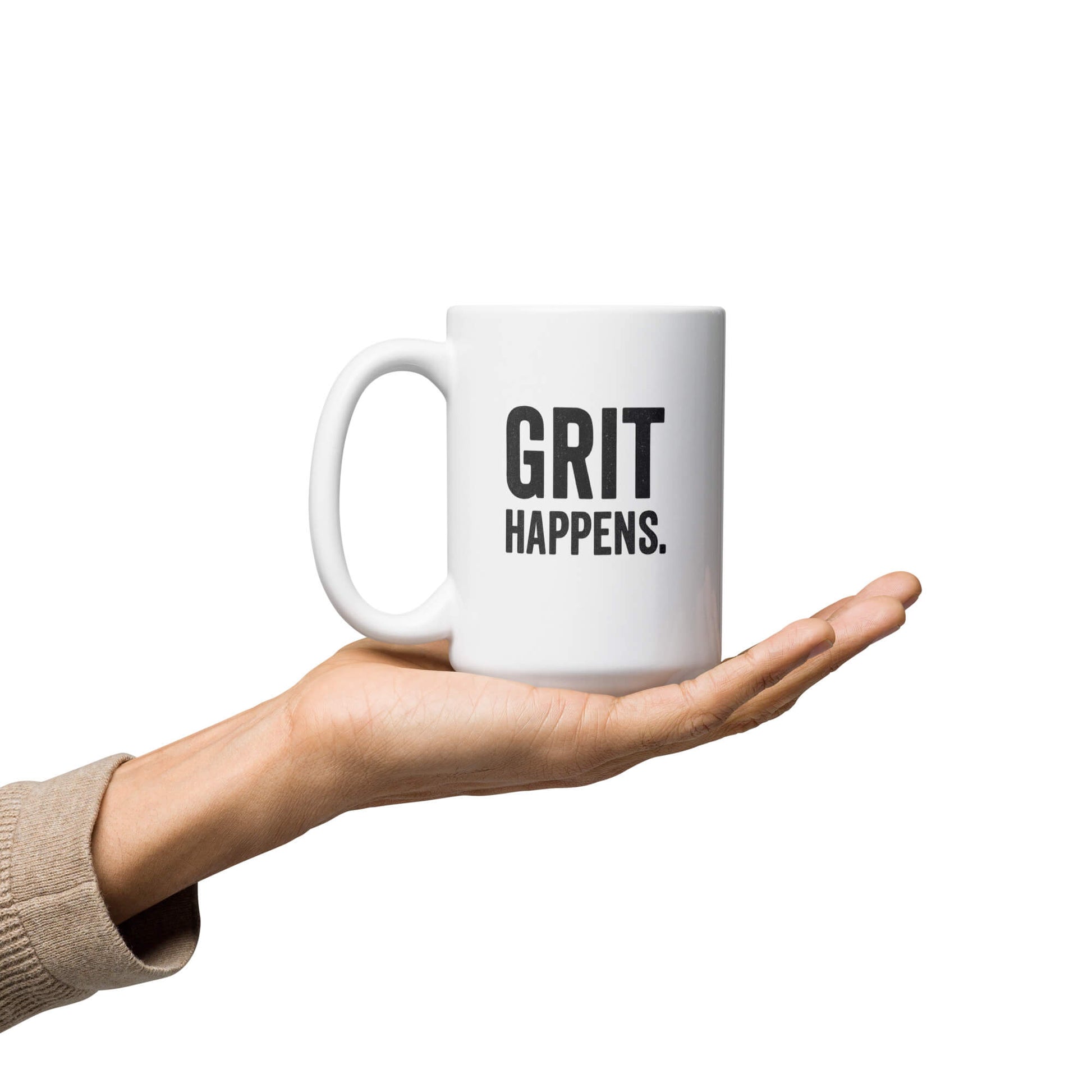 Hand holding the 15oz "Grit Happens" white glossy ceramic coffee mug by Grit Collective.