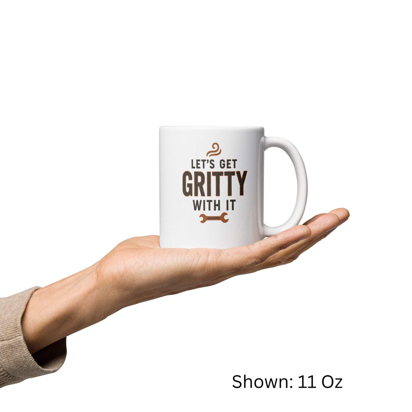 Let's Get Gritty With It" wrench design printed on an 11oz white glossy ceramic coffee mug, held in a hand.
