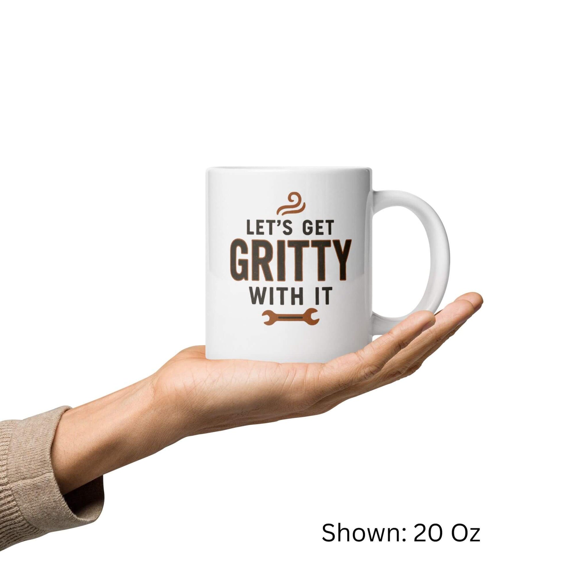Grit Collective "Let's Get Gritty With It" wrench design printed on a 20oz white glossy ceramic coffee mug, held in a hand.