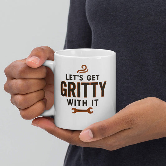 Let's Get Gritty With It" wrench design printed on a white glossy ceramic coffee mug, held by two hands.