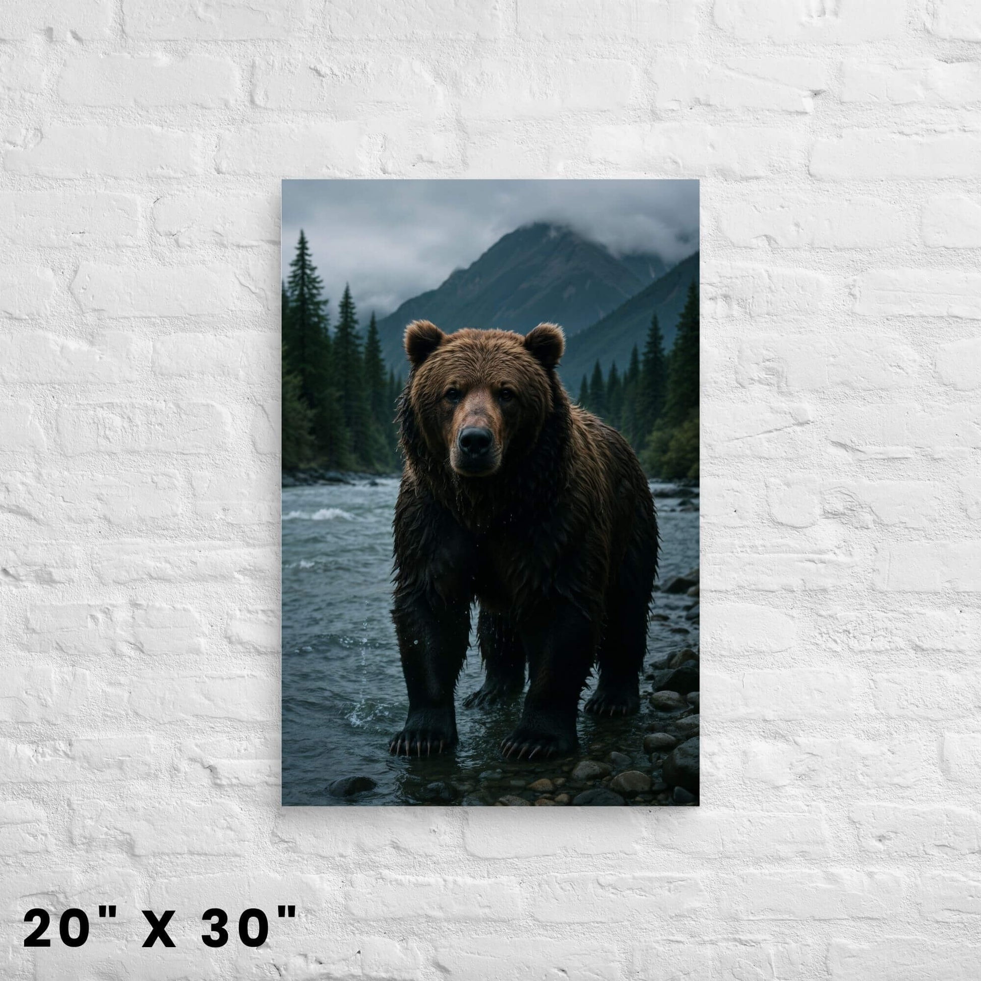 20 × 30-inch rugged grizzly bear canvas wall art with misty pine mountains and river foreground displayed on a clean white-brick wall.
