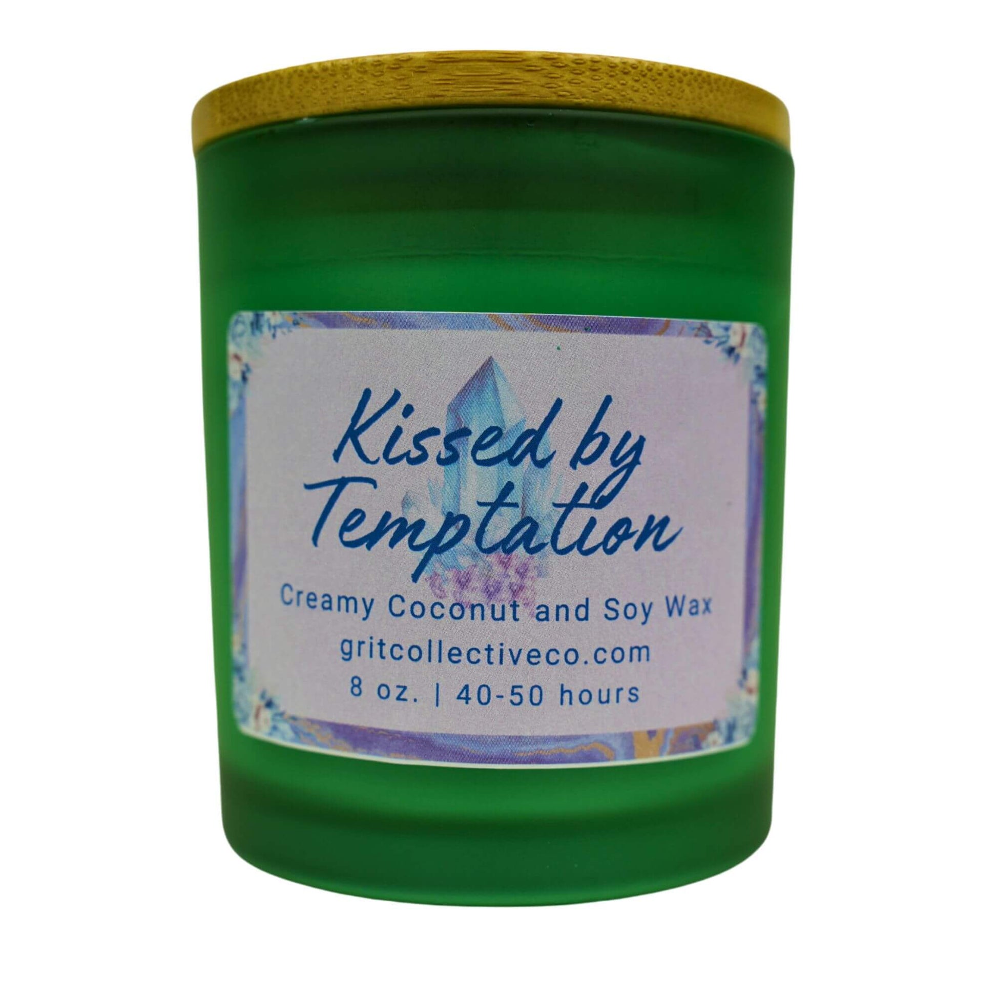 Kissed by Temptation" creamy coconut and soy wax candle by Grit Collective Co. in a green glass jar with a crystal-themed label and bamboo lid.