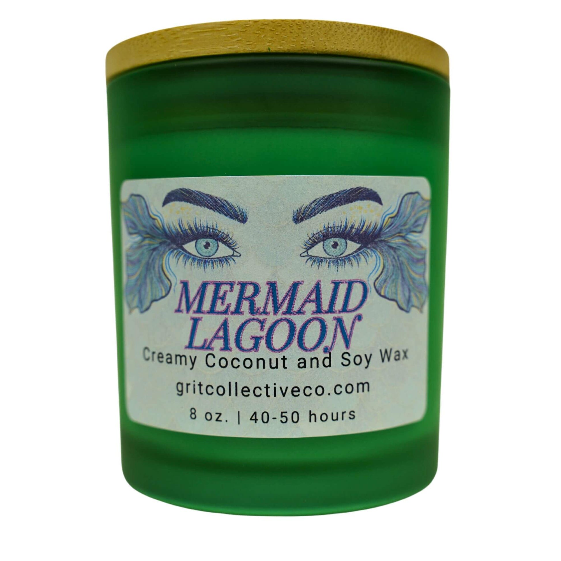Mermaid Lagoon" creamy coconut and soy wax candle by Grit Collective Co. in a green glass jar with a mermaid eye label and bamboo lid.