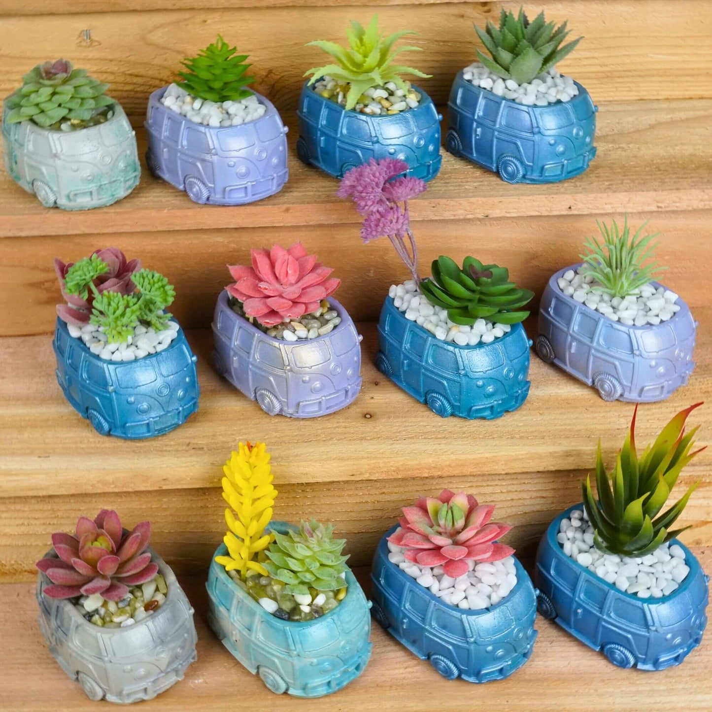 Collection of unique handmade mini retro bus concrete planters in various colors and styles with artificial succulents, arranged on wooden steps.