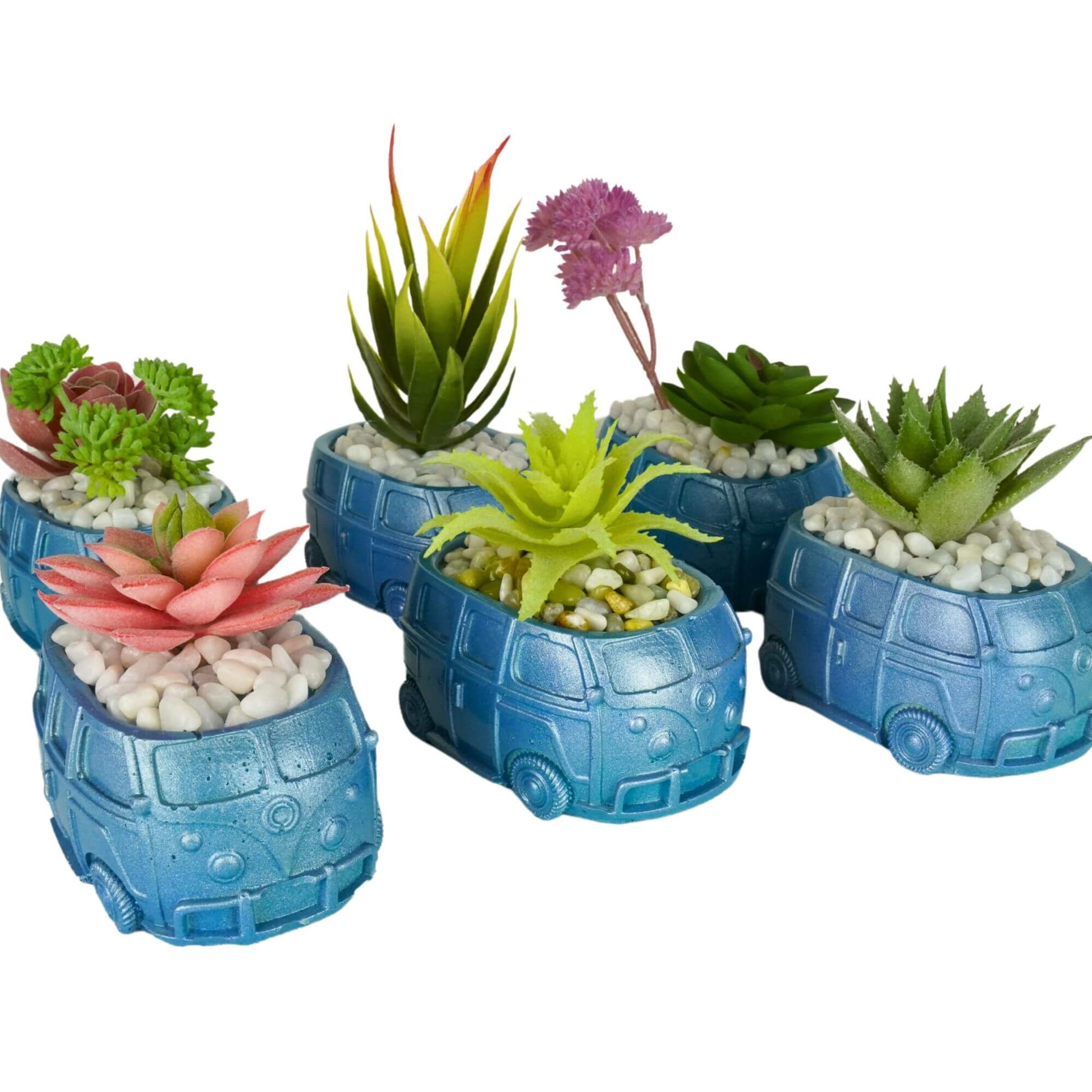A collection of five handmade mini retro bus concrete planters in metallic blue finishes with assorted artificial succulents and white and multi-colored pebbles.