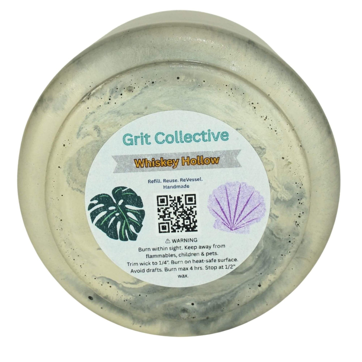Bottom view of a Grit Collective Sea Stone Concrete Candle showing the 'Whiskey Hollow' scent label, QR code, and warning information on the 6oz soy wax candle.