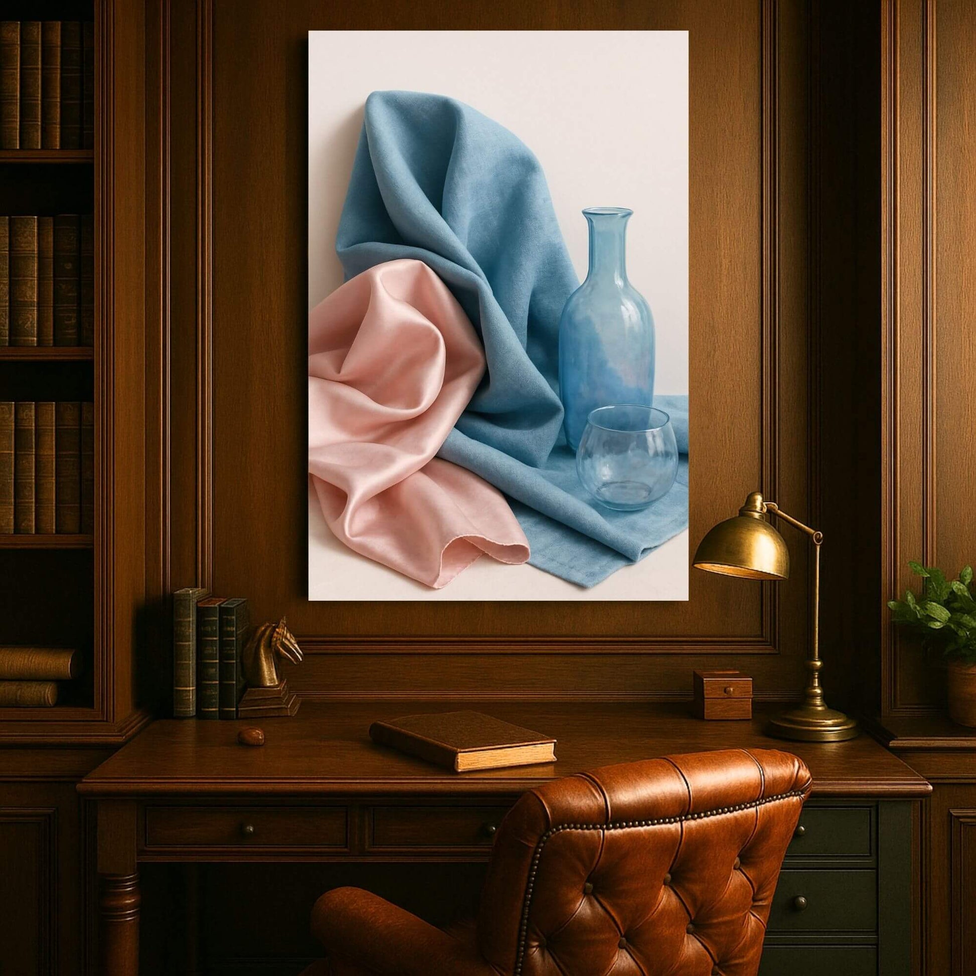 Canvas print of a still life with draped blue and pink fabric, a blue glass bottle, and a glass, displayed in a wood-paneled office setting.