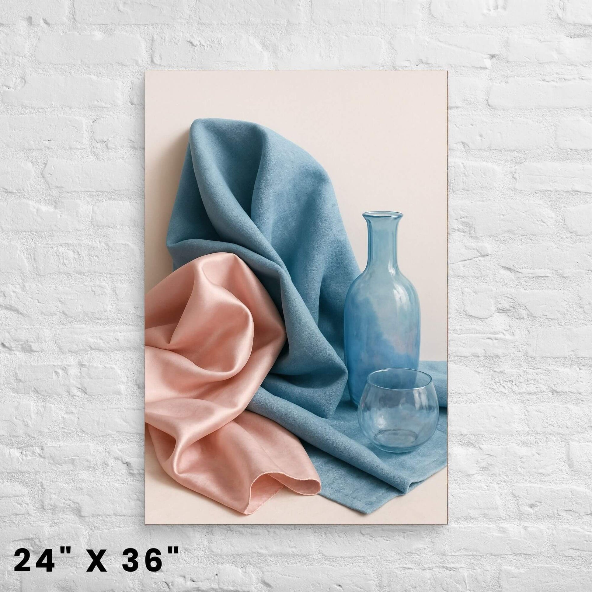 24"x36" canvas print depicting a still life with draped blue and pink fabric and glass objects, mounted on a white brick wall.