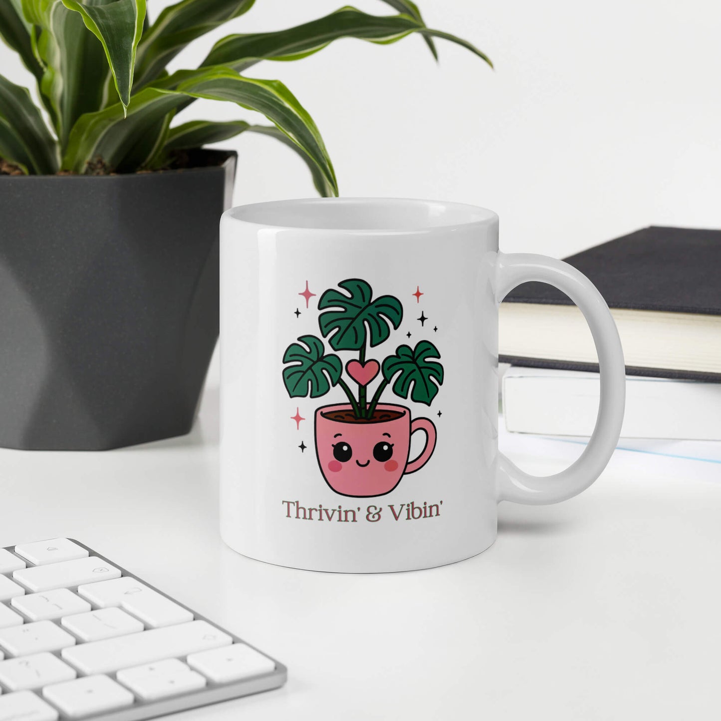 Grit Collective Kawaii Thriving Plant Pal design printed on an 11oz white glossy ceramic coffee mug, shown in an office environment.